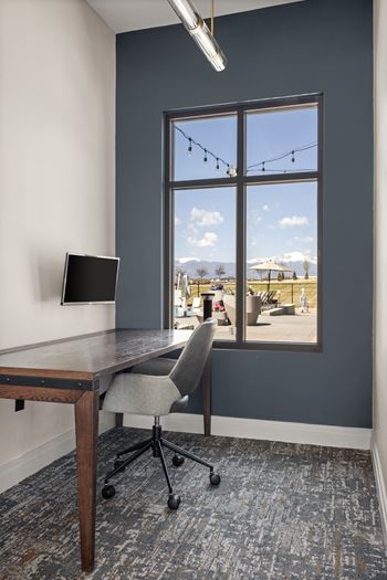 a home office with a desk and a window overlooking a patio at Upland Flats, Colorado, 80922